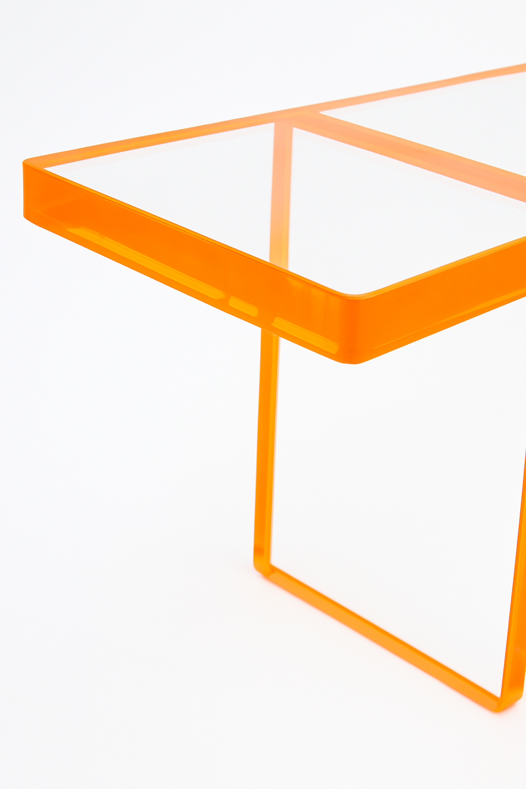 Stylish details of the Modern Acrylic Console Table featuring its transparent top and bright orange edges for a bold interior accent.